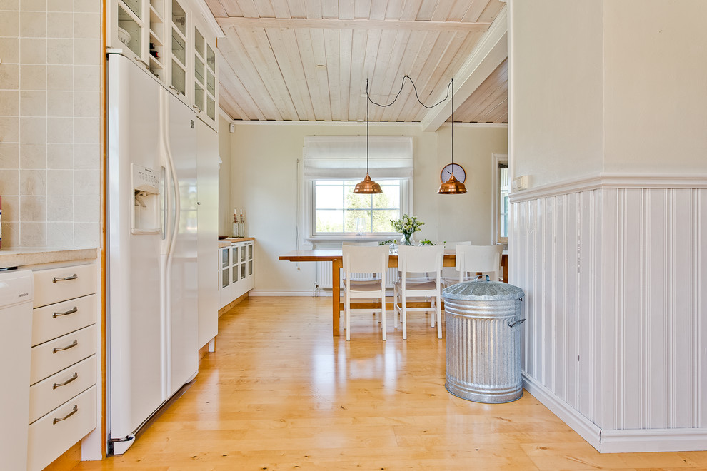 Inredning av en minimalistisk mellanstor matplats med öppen planlösning, med beige väggar, ljust trägolv och beiget golv