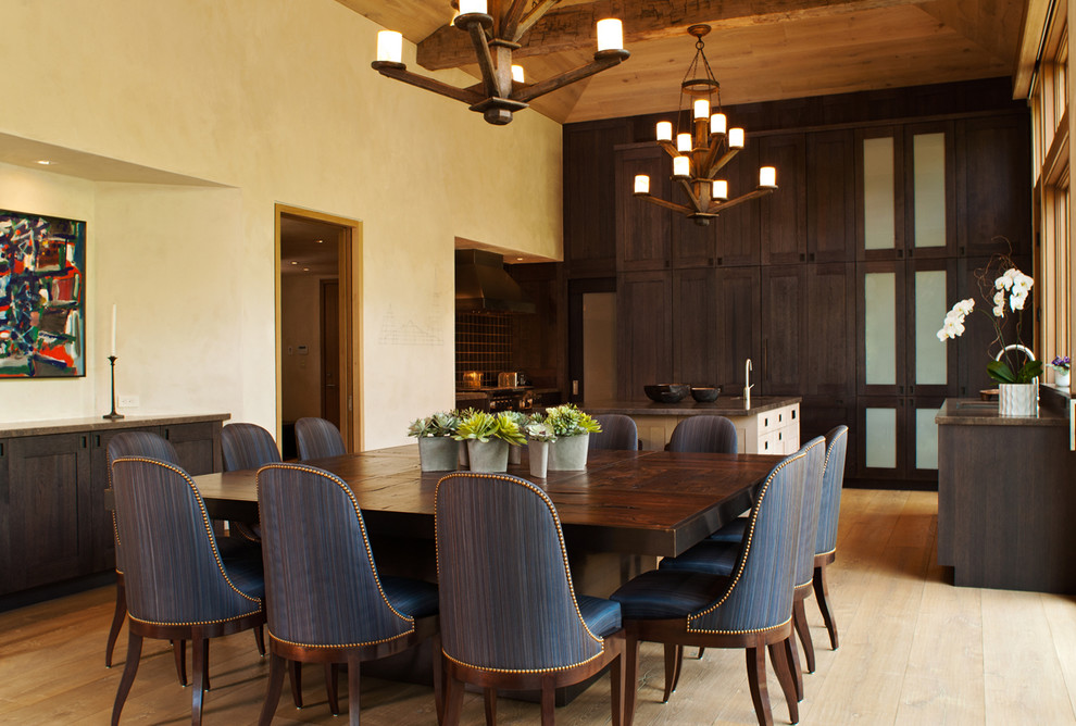 Cette photo montre une grande salle à manger ouverte sur la cuisine tendance avec un mur beige, un sol en bois brun et aucune cheminée.
