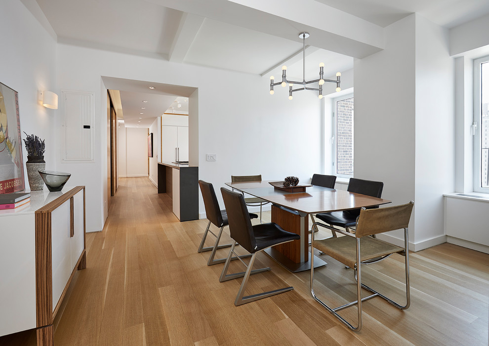 Cette image montre une salle à manger design fermée avec un mur blanc, un sol en bois brun et un sol beige.