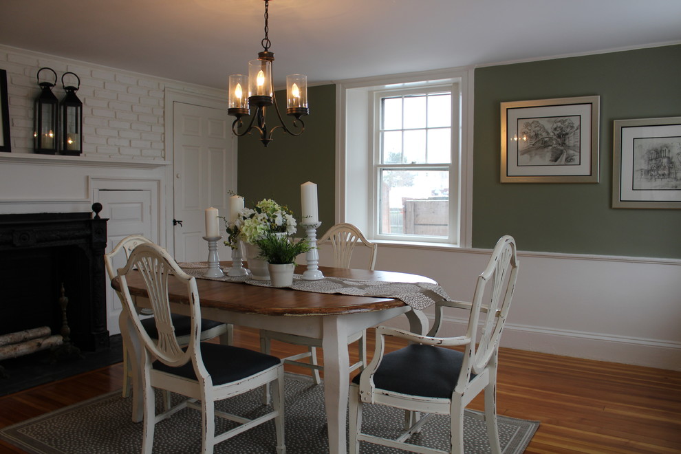 Photo of a medium sized classic enclosed dining room in Boston with green walls, medium hardwood flooring, a standard fireplace and a wooden fireplace surround.