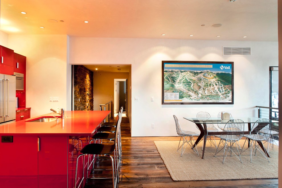 Immagine di una sala da pranzo aperta verso la cucina minimalista di medie dimensioni con pareti bianche, parquet scuro, nessun camino e pavimento marrone