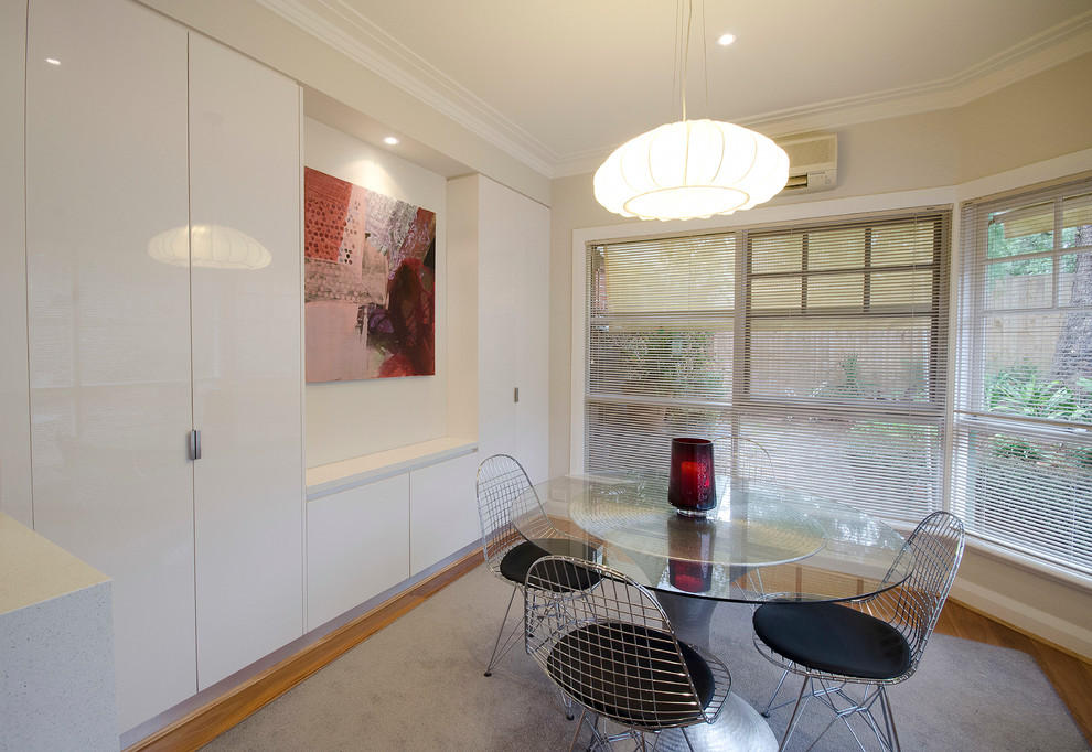 Ispirazione per una piccola sala da pranzo aperta verso la cucina design con pavimento in legno massello medio e pareti beige