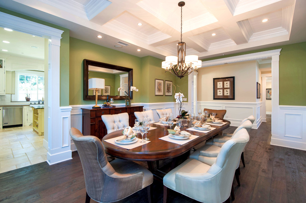Cette image montre une salle à manger traditionnelle avec un mur vert, parquet foncé et éclairage.