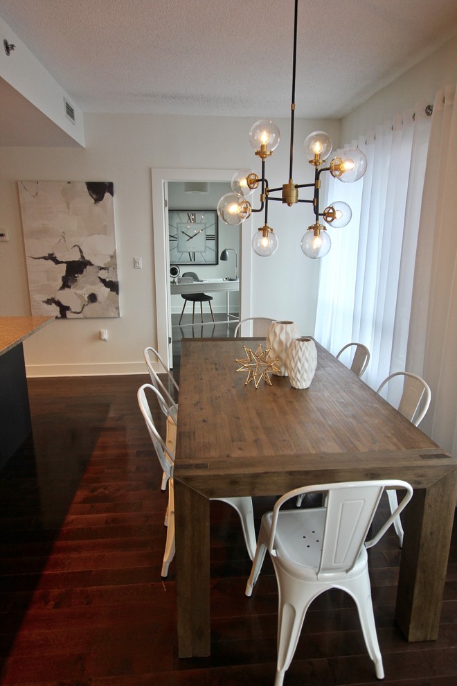 Réalisation d'une salle à manger ouverte sur le salon minimaliste de taille moyenne avec un mur blanc, parquet foncé, aucune cheminée et un sol marron.