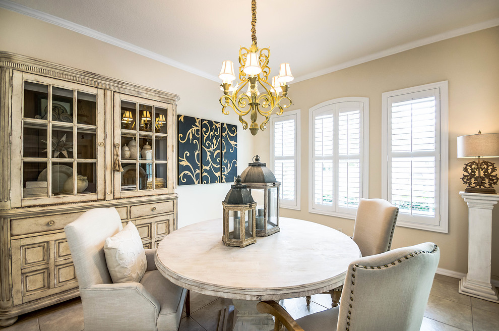 Exemple d'une salle à manger chic de taille moyenne et fermée avec un mur beige, un sol en travertin, aucune cheminée et un sol beige.