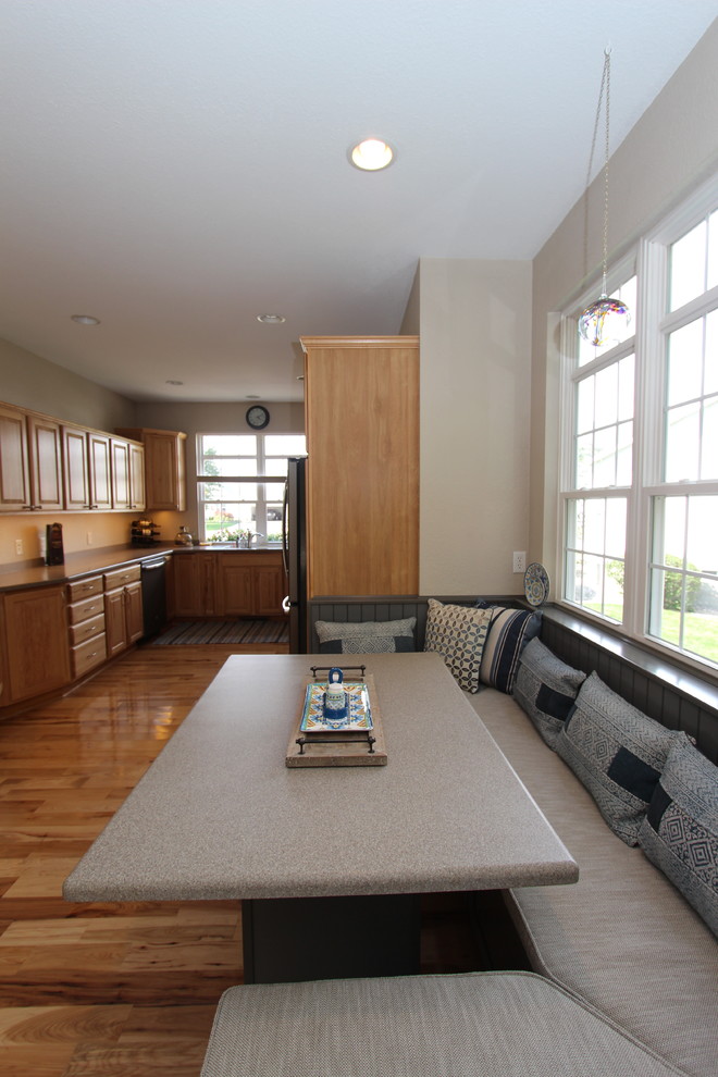 На фото: кухня-столовая среднего размера в стиле неоклассика (современная классика) с бежевыми стенами, светлым паркетным полом, стандартным камином и фасадом камина из дерева
