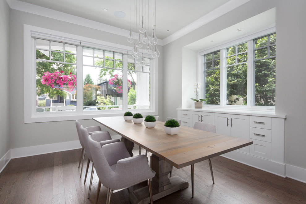 Photo of a medium sized classic enclosed dining room in Vancouver with grey walls, medium hardwood flooring, no fireplace and brown floors.