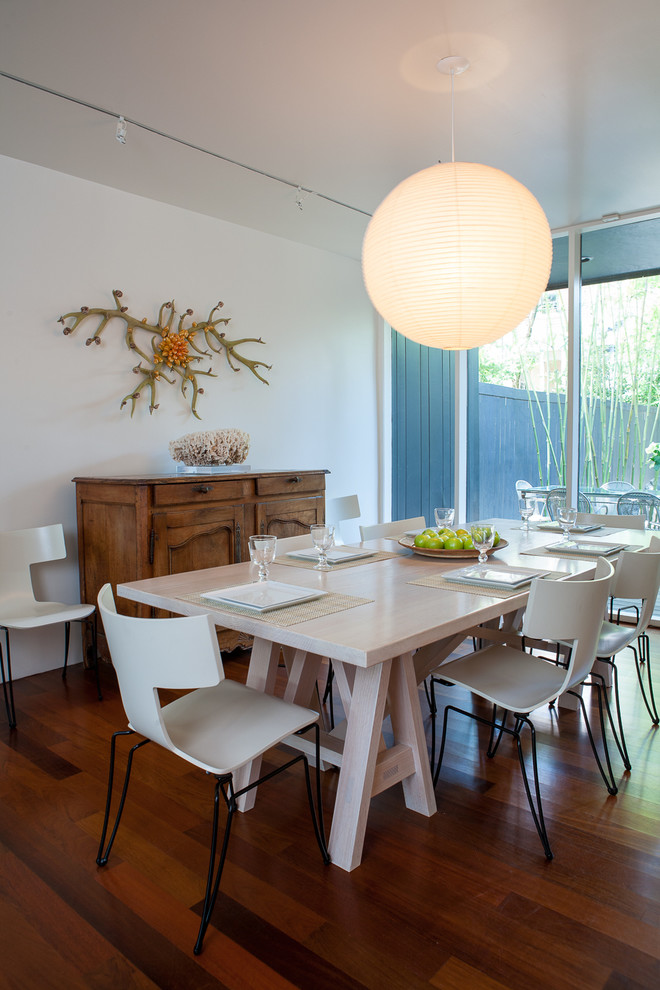Large midcentury dining room in New Orleans with white walls and dark hardwood flooring.