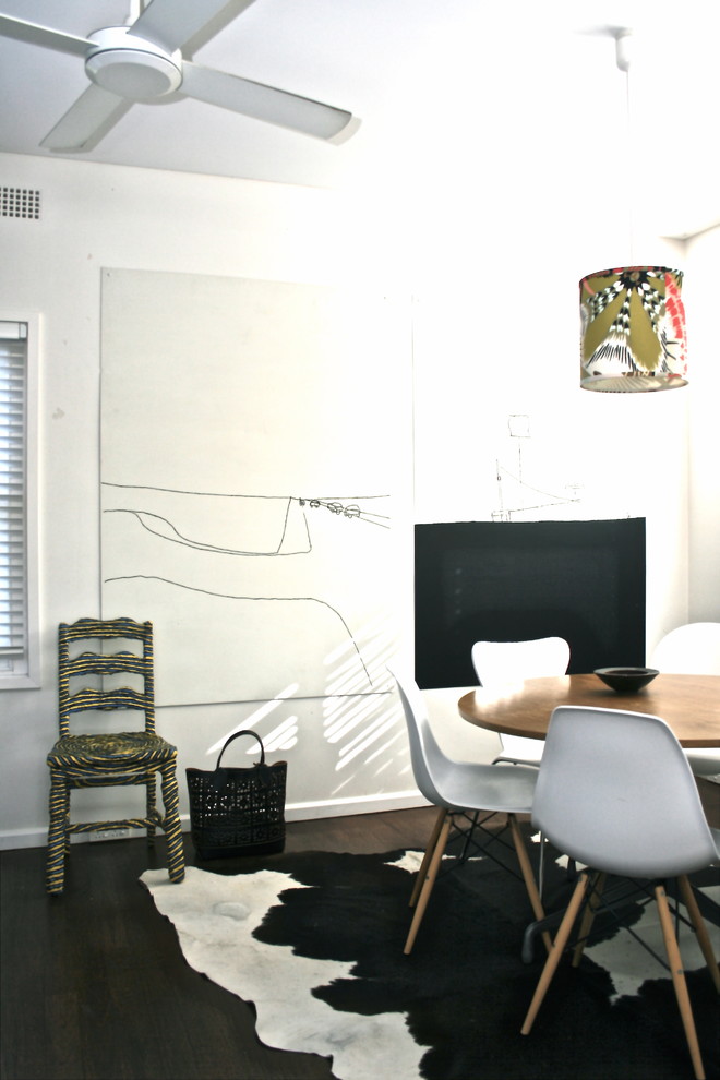 На фото: столовая в стиле фьюжн с белыми стенами и темным паркетным полом с