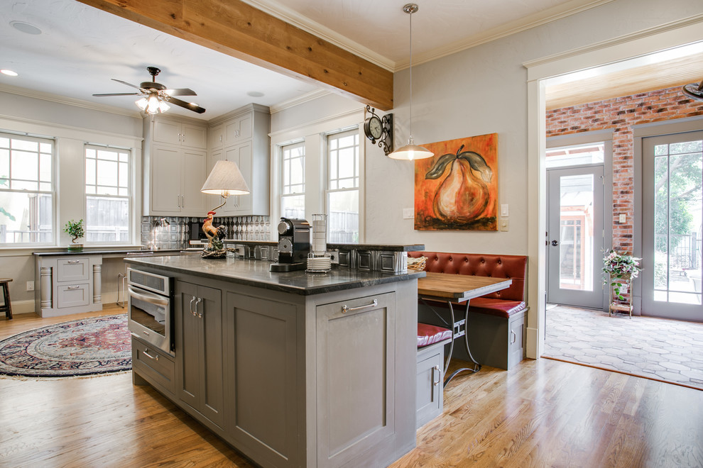 Foto de comedor de cocina de estilo americano de tamaño medio sin chimenea con paredes grises y suelo de madera clara