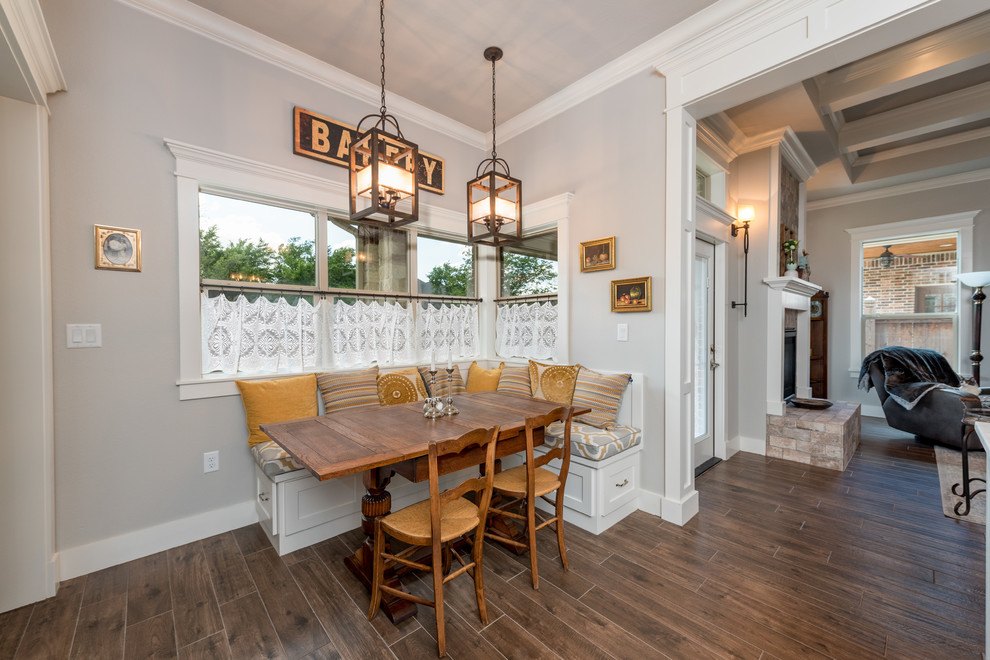 Medium sized classic kitchen/dining room in Other with grey walls, ceramic flooring, a two-sided fireplace, a brick fireplace surround and brown floors.