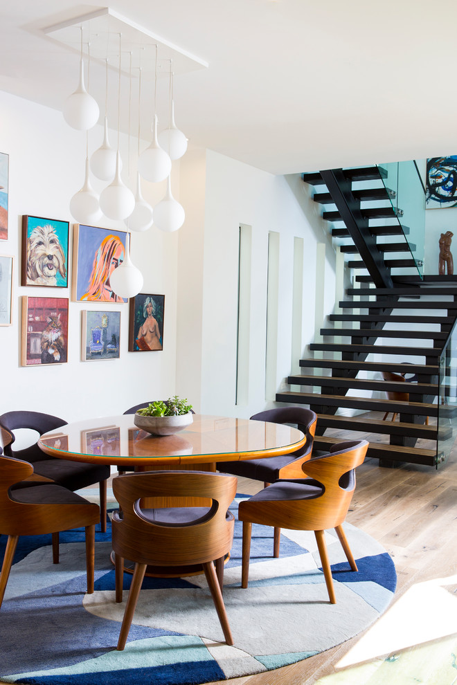 Aménagement d'une grande salle à manger contemporaine avec un mur blanc, un sol marron et parquet clair.