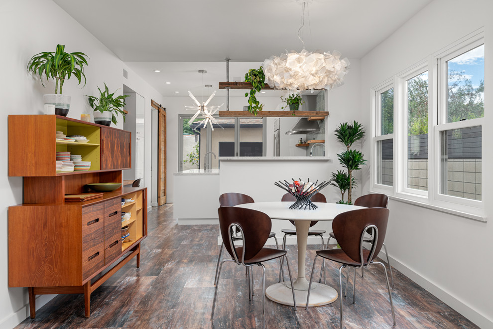 Inspiration pour une salle à manger design avec un mur blanc, un sol en bois brun et un sol multicolore.