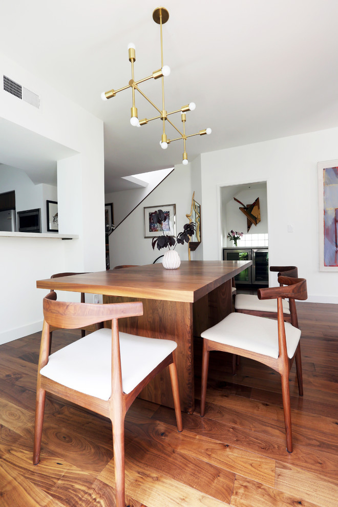 Photo of a medium sized modern kitchen/dining room in Los Angeles with white walls, dark hardwood flooring and brown floors.