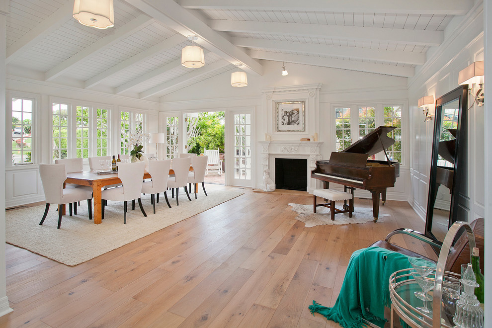 Aménagement d'une grande salle à manger ouverte sur le salon éclectique avec un sol en bois brun, un mur blanc, une cheminée standard et un manteau de cheminée en bois.