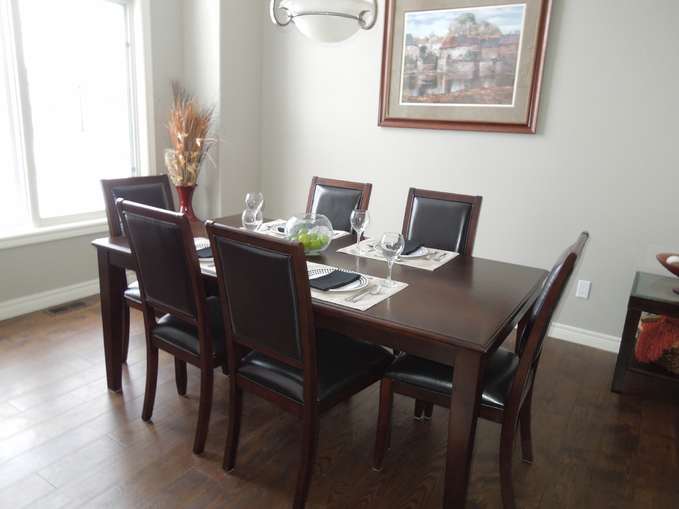 Foto di una sala da pranzo aperta verso la cucina chic con pareti grigie e pavimento in legno massello medio