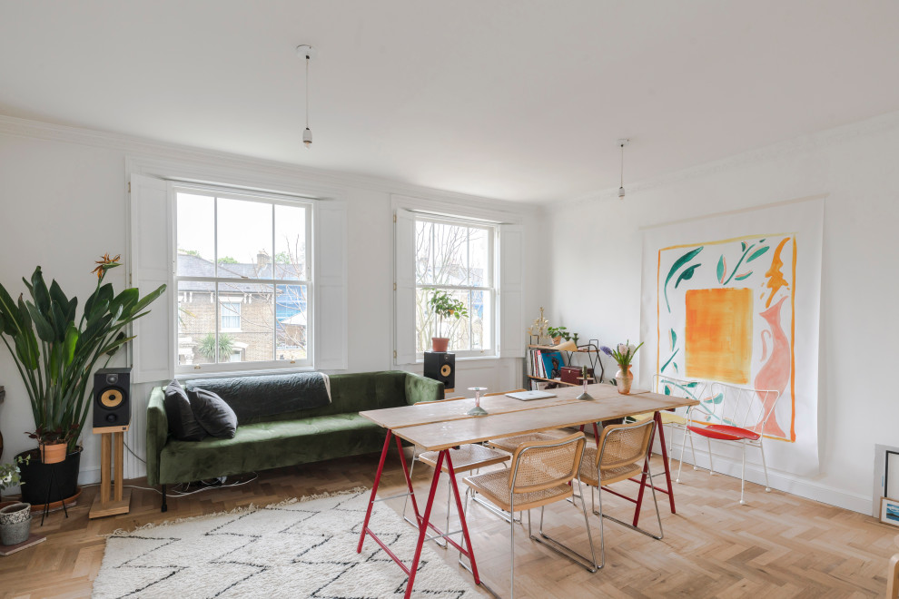 Offenes Stilmix Esszimmer mit weißer Wandfarbe, braunem Holzboden und braunem Boden in London