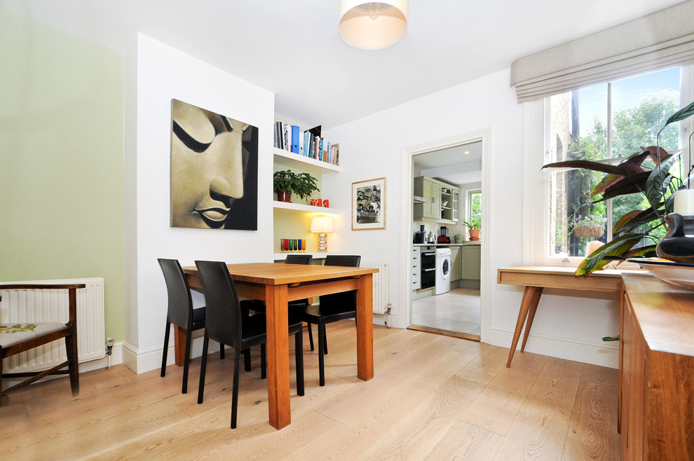 Small beach style light wood floor enclosed dining room photo in Surrey with white walls