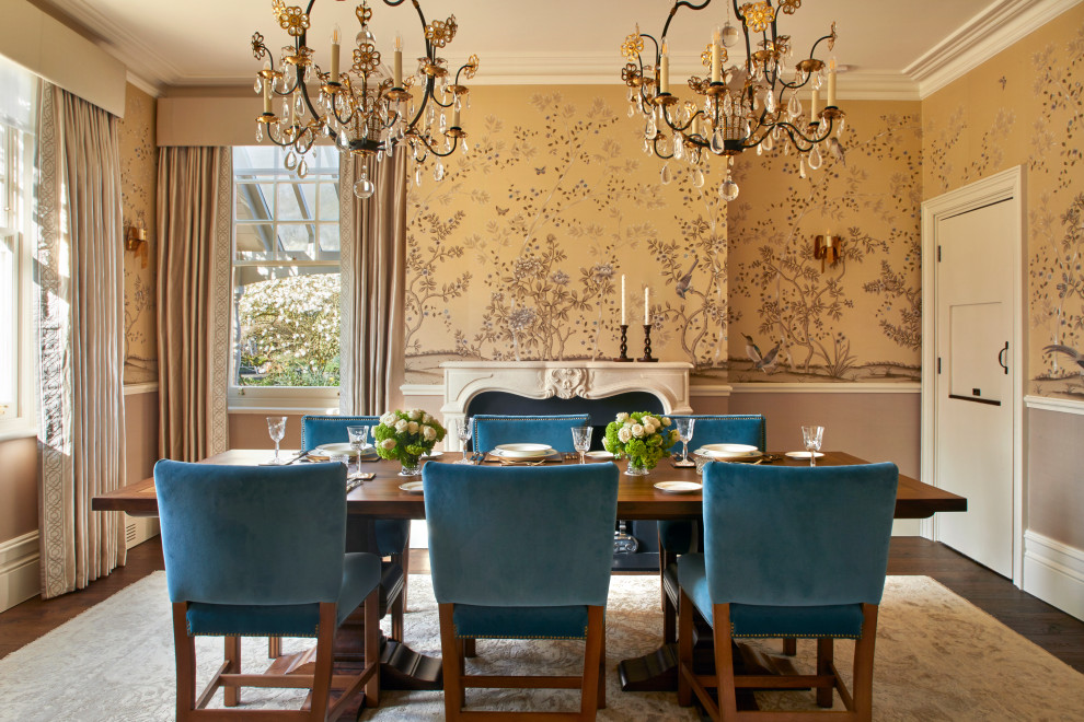 This is an example of a medium sized classic enclosed dining room in Surrey with yellow walls, dark hardwood flooring, a standard fireplace, a stone fireplace surround, brown floors, wallpapered walls and a chimney breast.