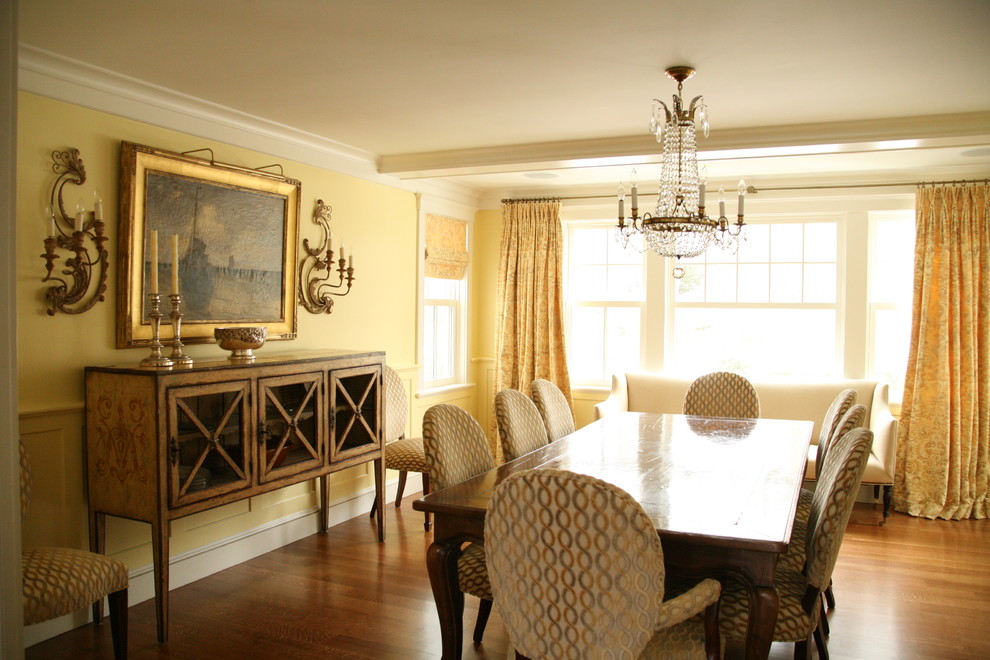 Mid-sized elegant plywood floor enclosed dining room photo in Boston with yellow walls