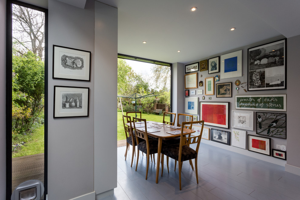 Kitchen/dining room combo - mid-sized contemporary painted wood floor and gray floor kitchen/dining room combo idea in London with white walls