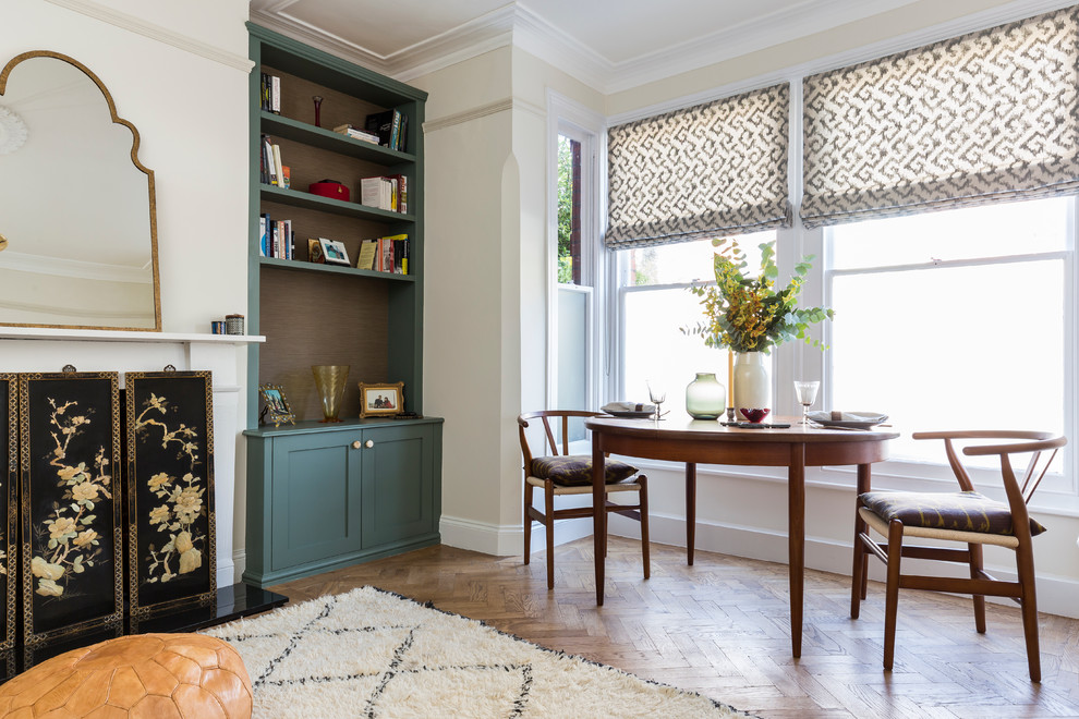 This is an example of a medium sized retro dining room in London with white walls and medium hardwood flooring.