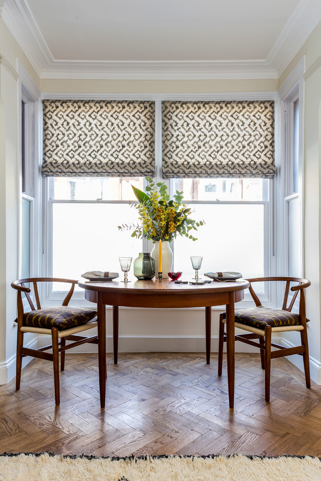 Photo of a medium sized midcentury dining room in London with white walls and medium hardwood flooring.