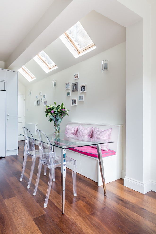 Inspiration for a contemporary medium tone wood floor dining room remodel in London with white walls