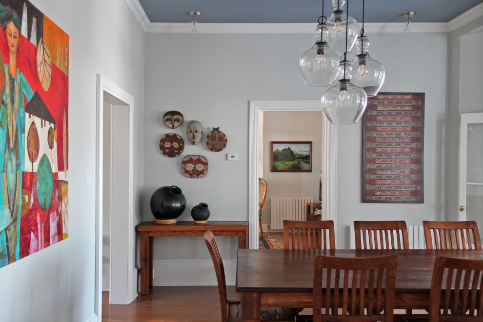 Modelo de comedor tradicional grande cerrado con paredes azules, suelo de madera en tonos medios y suelo marrón