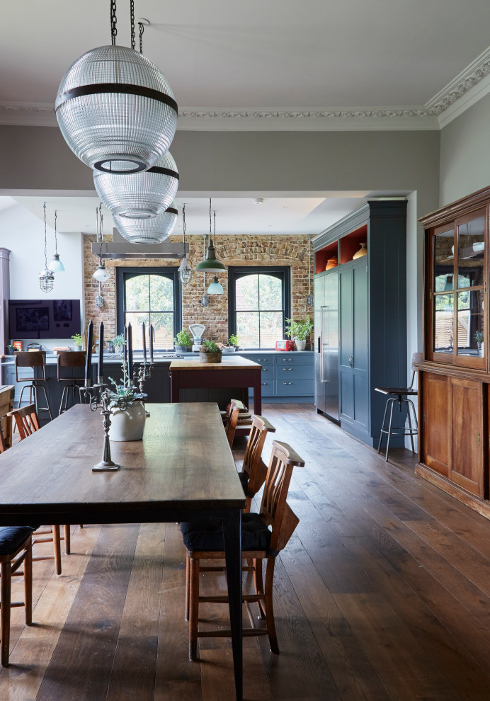 This is an example of an expansive eclectic dining room in London with grey walls, dark hardwood flooring and brown floors.