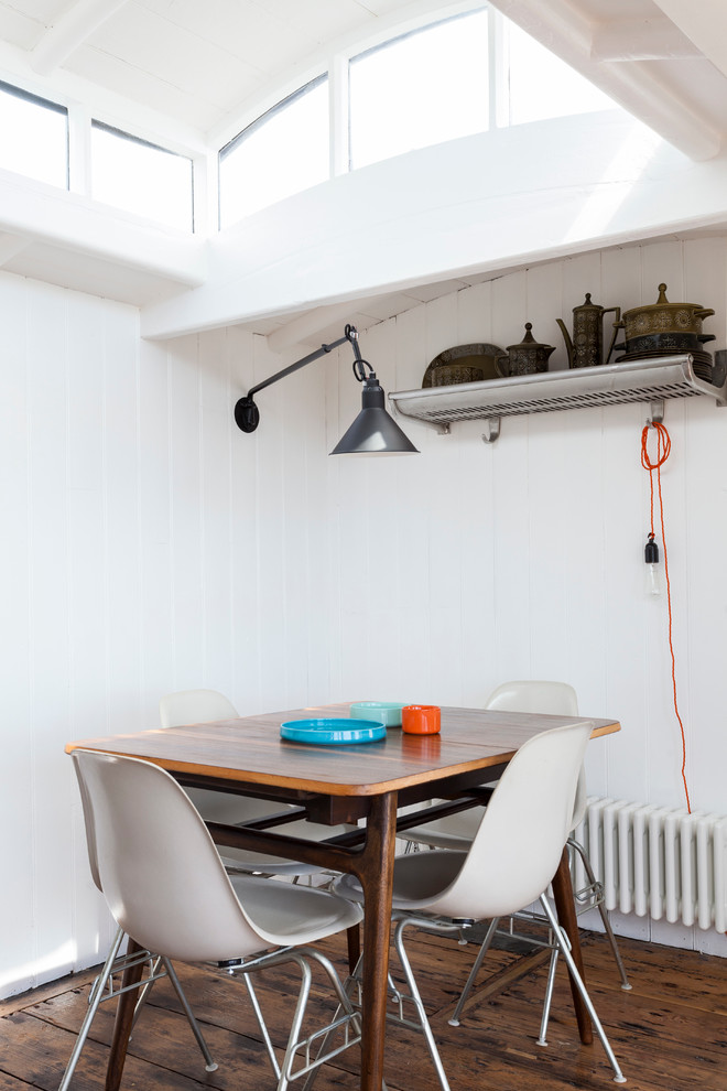 Imagen de comedor escandinavo con paredes blancas y suelo de madera oscura