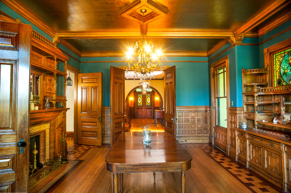 Источник вдохновения для домашнего уюта: большая отдельная столовая в викторианском стиле с синими стенами, паркетным полом среднего тона, стандартным камином, фасадом камина из плитки и коричневым полом