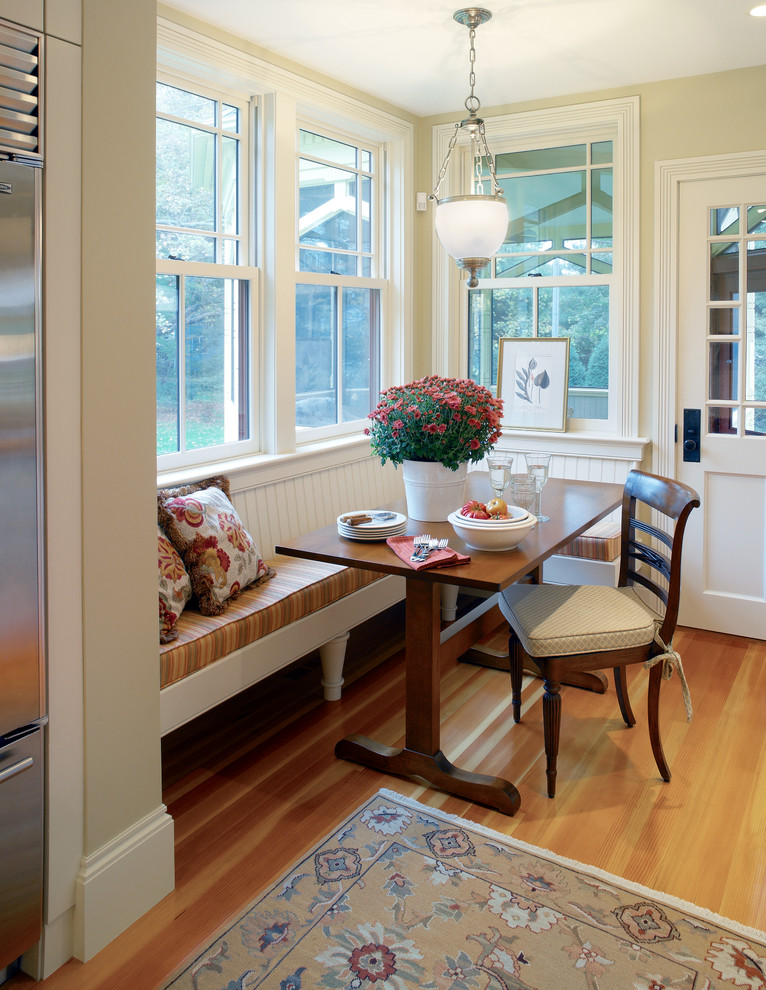 Idées déco pour une salle à manger ouverte sur la cuisine victorienne avec un mur beige et un sol en bois brun.