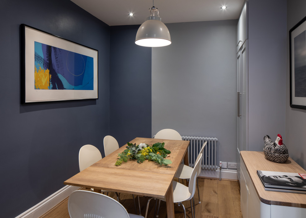 Kleine Moderne Wohnküche mit blauer Wandfarbe, braunem Holzboden und braunem Boden in London