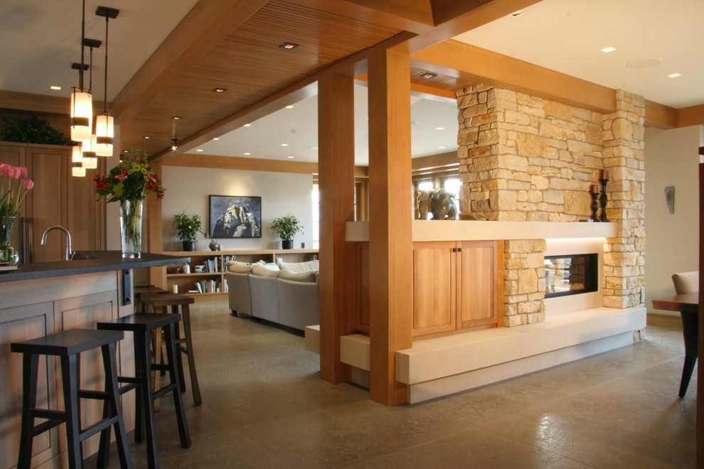 Свежая идея для дизайна: большая кухня-столовая в современном стиле с серыми стенами, полом из керамогранита, двусторонним камином, фасадом камина из камня, серым полом и балками на потолке - отличное фото интерьера
