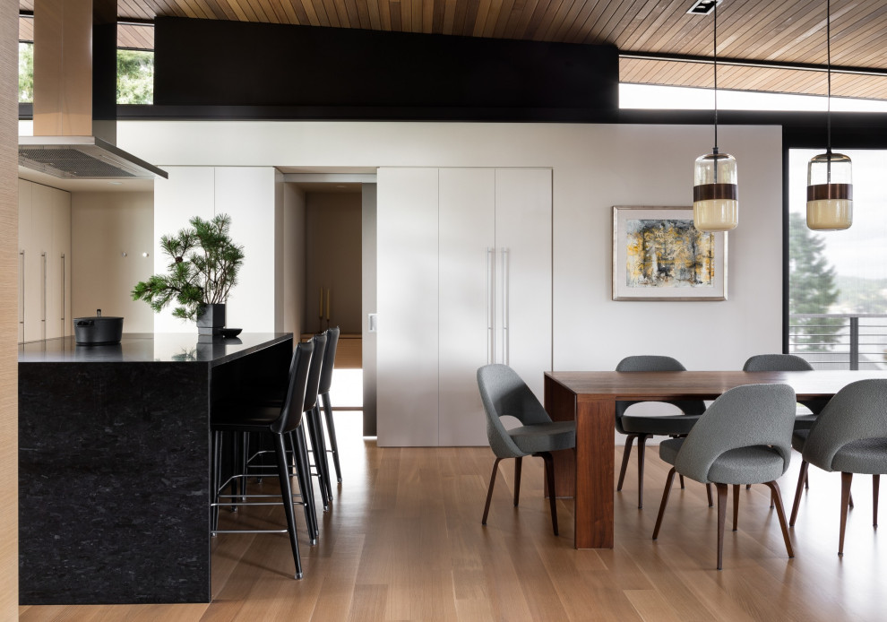 Offenes Modernes Esszimmer mit weißer Wandfarbe, braunem Holzboden und Holzdecke in Seattle