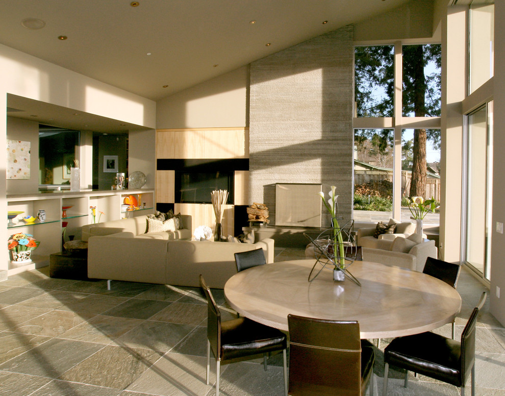 Свежая идея для дизайна: гостиная-столовая в современном стиле с серыми стенами, полом из сланца, стандартным камином и фасадом камина из камня - отличное фото интерьера