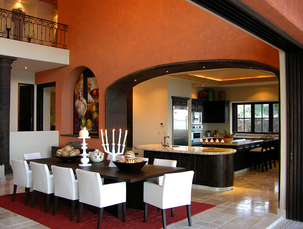 На фото: столовая в средиземноморском стиле с оранжевыми стенами с