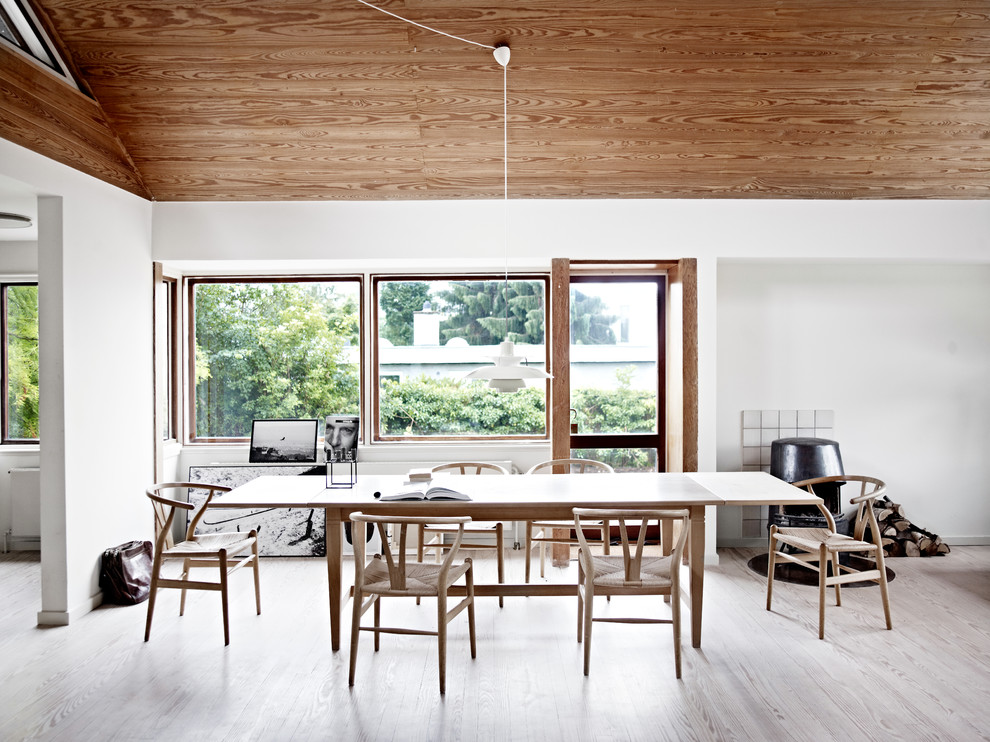 This is an example of a scandi dining room in Copenhagen with white walls, light hardwood flooring and beige floors.