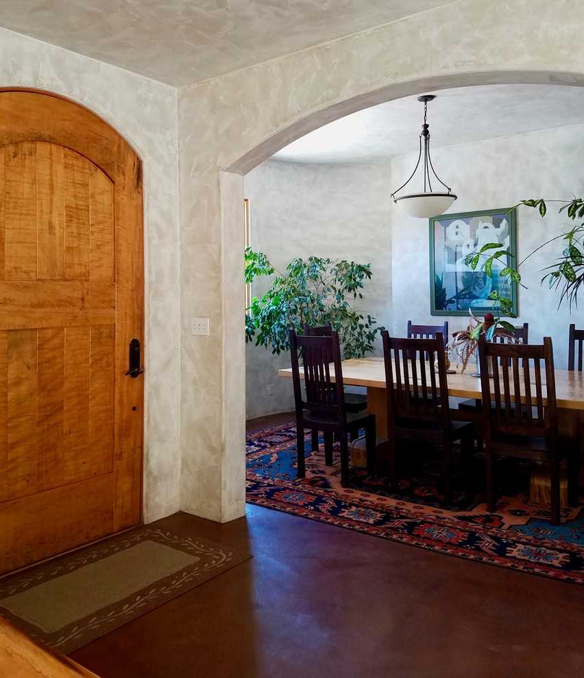 Cette image montre une petite salle à manger méditerranéenne avec un mur beige, sol en béton ciré, un sol marron et aucune cheminée.