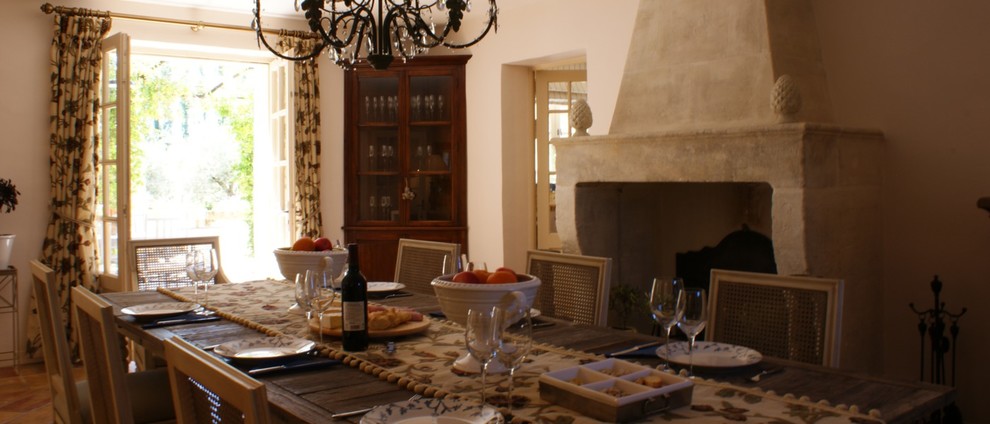 Foto di una grande sala da pranzo tradizionale chiusa con pareti beige, pavimento in pietra calcarea, camino classico e cornice del camino in pietra