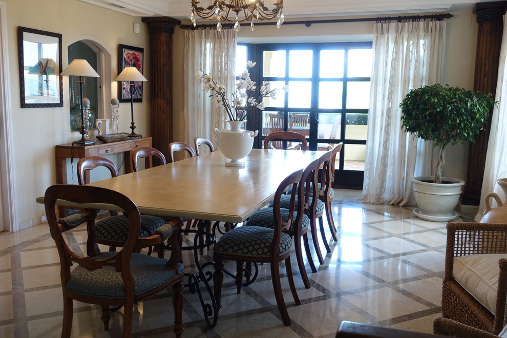 На фото: большая гостиная-столовая в средиземноморском стиле с бежевыми стенами и полом из керамогранита без камина