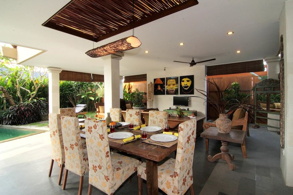 Idee per una sala da pranzo aperta verso il soggiorno tropicale di medie dimensioni con pareti bianche e pavimento in pietra calcarea