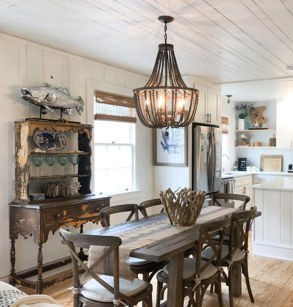 Immagine di una sala da pranzo aperta verso la cucina stile marino di medie dimensioni con pareti bianche, parquet chiaro, pavimento beige e pareti in legno