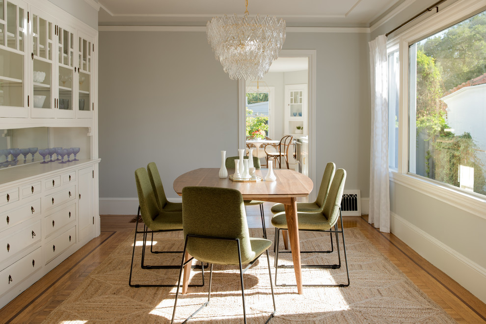 Immagine di una sala da pranzo classica chiusa con pareti grigie e parquet chiaro