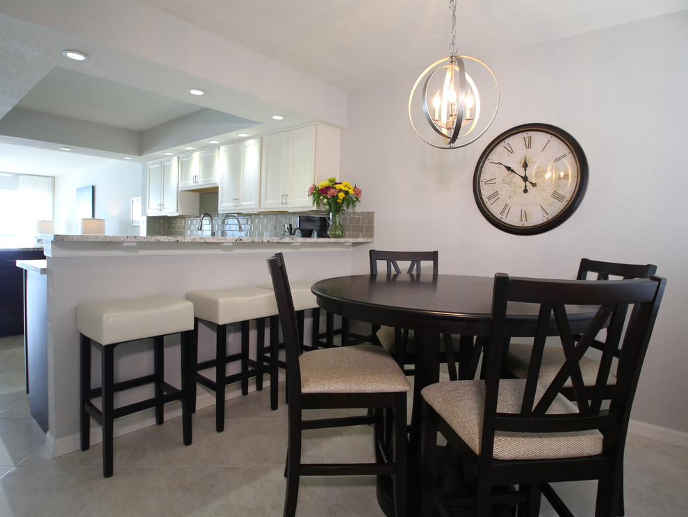 Immagine di una grande sala da pranzo aperta verso la cucina stile marinaro con pavimento in marmo, pareti blu e nessun camino