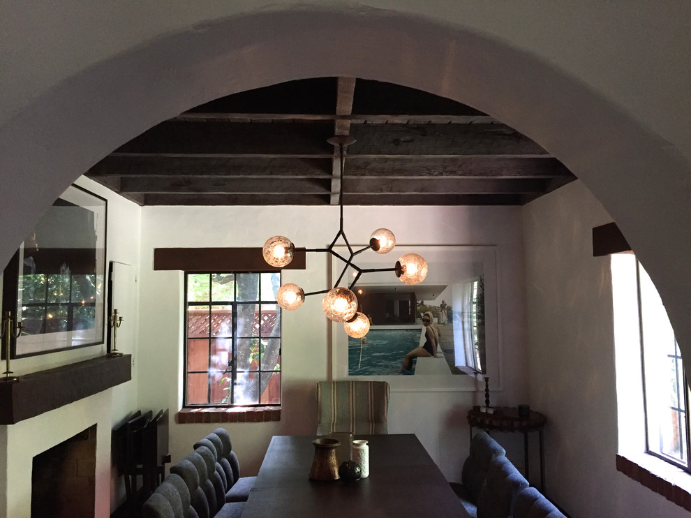 Esempio di una sala da pranzo bohémian chiusa e di medie dimensioni con pareti beige, parquet scuro, camino classico e cornice del camino in legno