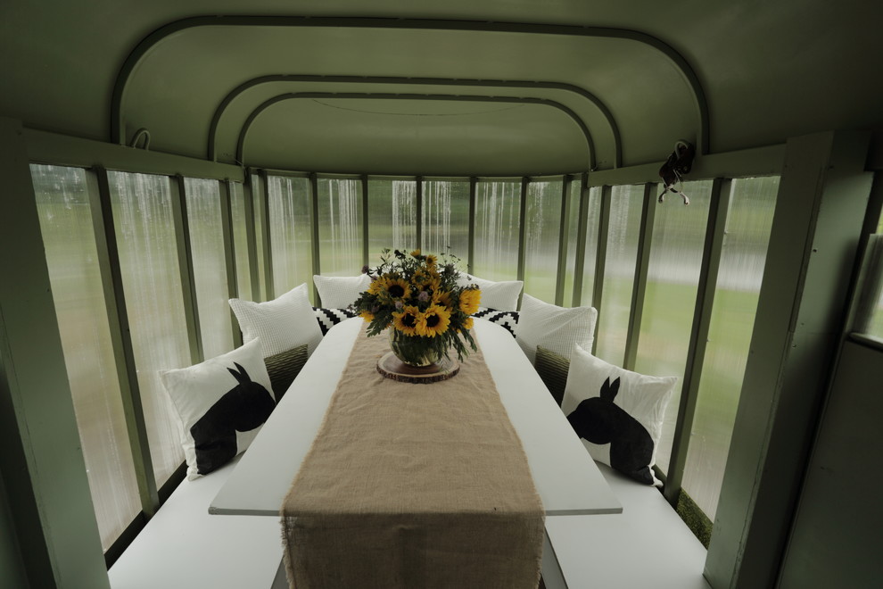 Immagine di una piccola sala da pranzo aperta verso la cucina country con pareti verdi e pavimento in laminato