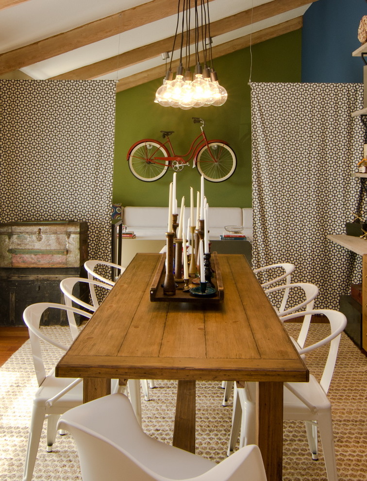 Imagen de comedor bohemio de tamaño medio con paredes verdes, suelo de madera en tonos medios y cortinas