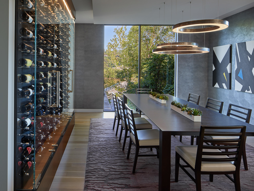 Expansive contemporary enclosed dining room in DC Metro with grey walls, light hardwood flooring, no fireplace and brown floors.